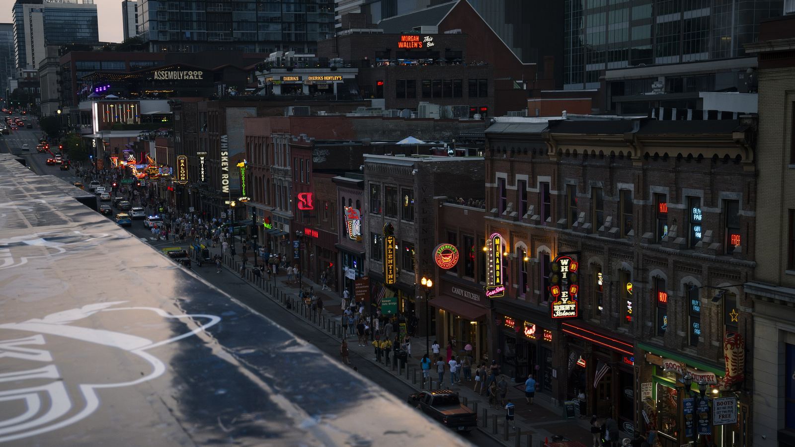 Lower Broadway in downtown Nashville lined with honky-tonk bars and neon signs, seen from above