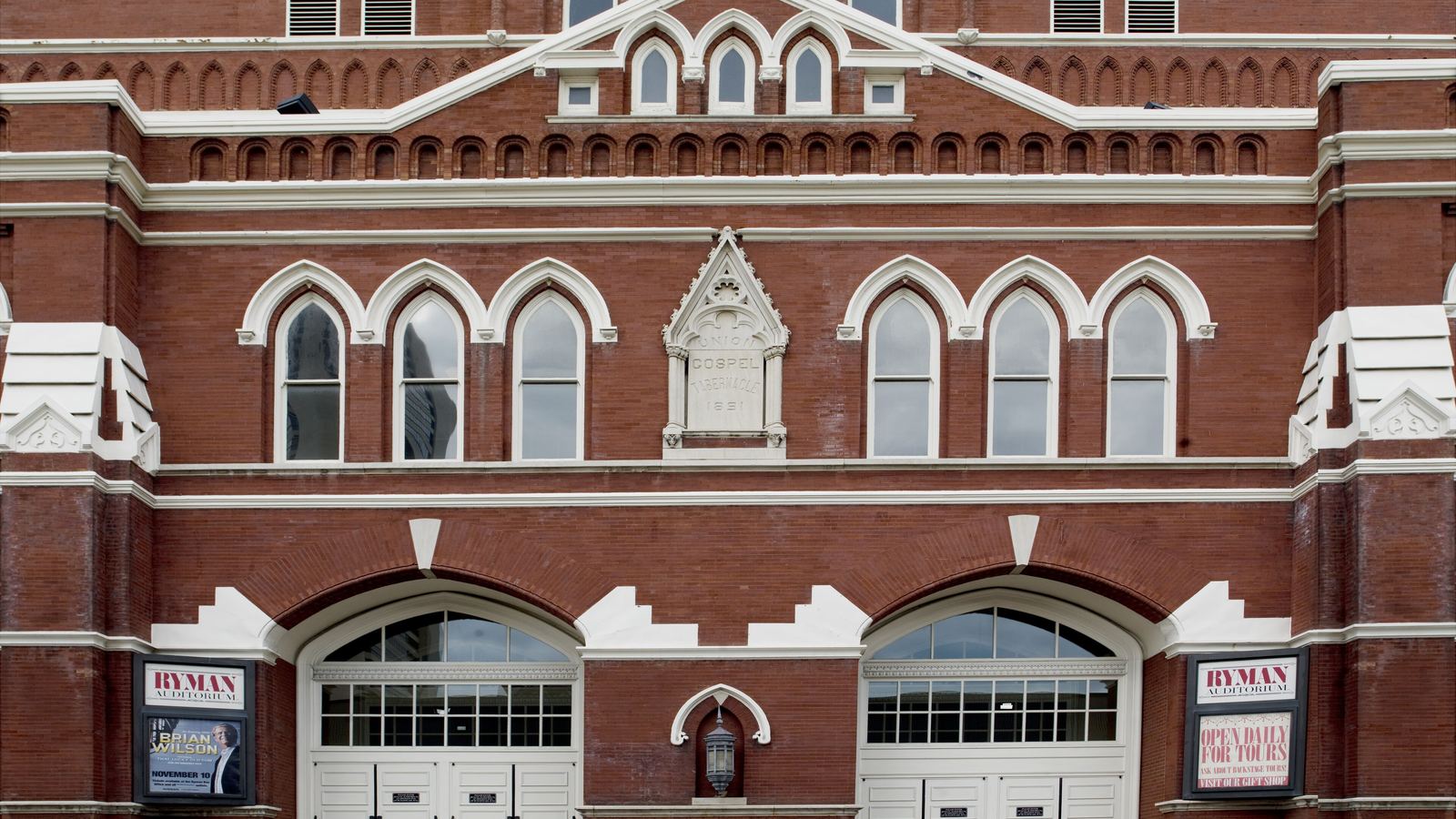 The red-brick front of the Ryman Auditorium in Nashville with its arched windows and doors